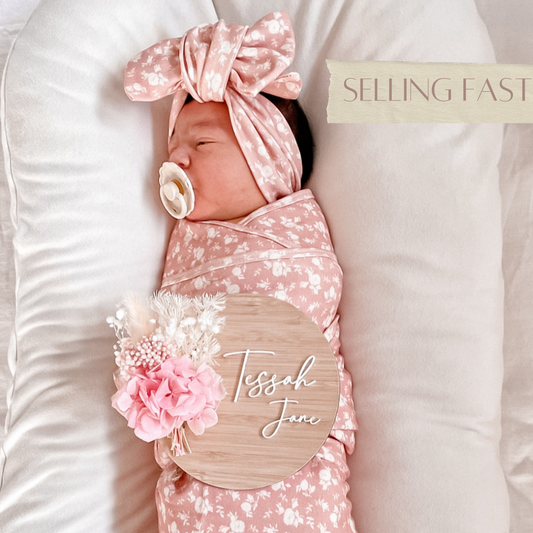 Bright pink and white dried flower baby name sign