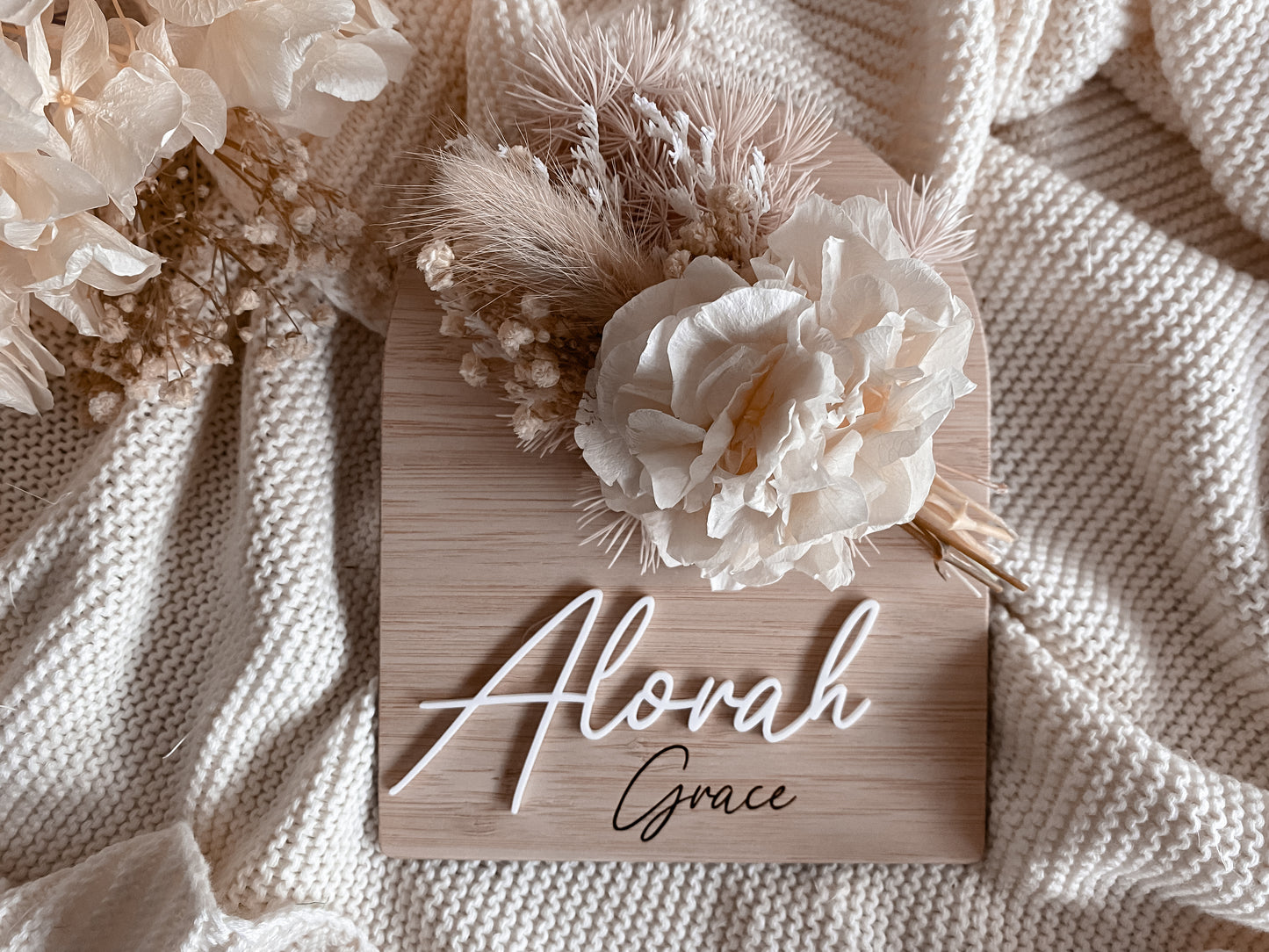 Baby name sign with light brown dried flowers