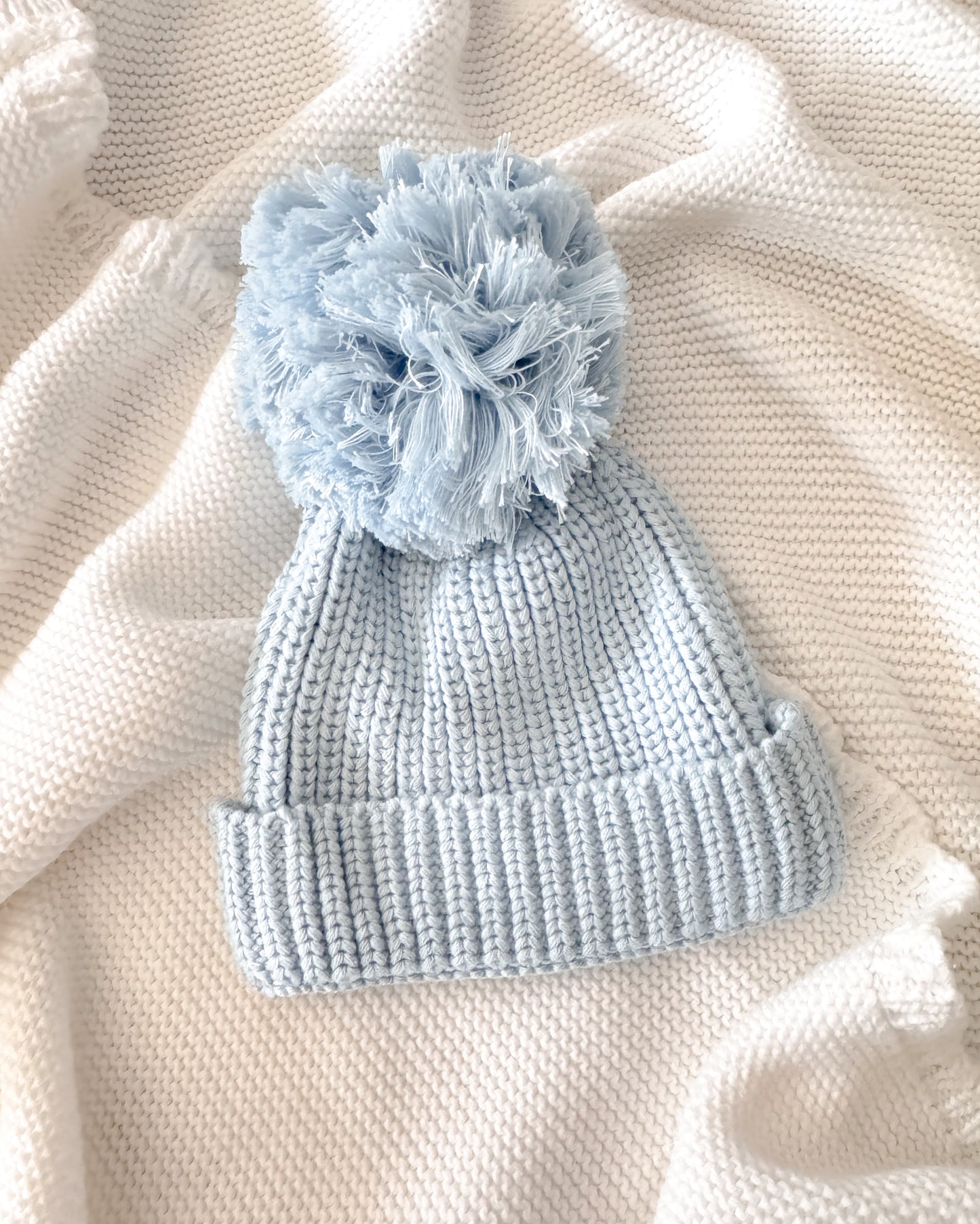 Blue knit pompom newborn hat